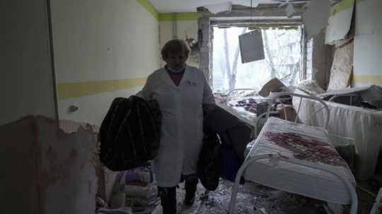 Zdravotníčka kráča v zničenej budove pôrodnice po ostreľovaní v Mariupole.