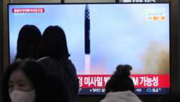 ľudia sledujú odpálenie rakety v TV