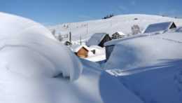 Na ilustračnej snímke domy zaviate snehom.