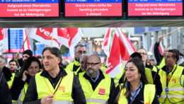 Štrajkujúci zamestnanci letiska v stoja v termináli letiska v nemeckom Düsseldorfe.