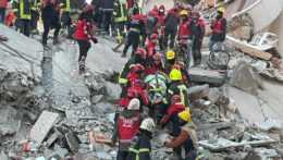 Záchranári vyslobodzujú ľudí spod trosiek zrútenej budovy v Turecku.