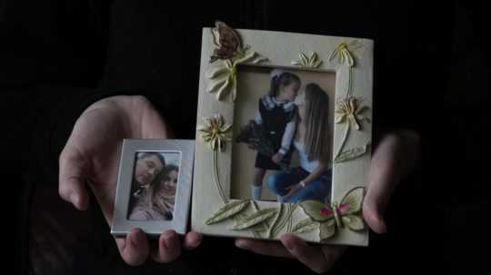 Tridsaťštyriročná Viktoria Kovalenková z Ukrajiny ukazuje fotografie so svojím manželom a 12- ročnou dcérou v dedine v grófstve Kent na juhovýchode Anglicka vo štvrtok 9. februára 2023.