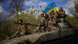 Ukrajinskí vojaci na obrnenom vozidle s ukrajinskou vlajkou.