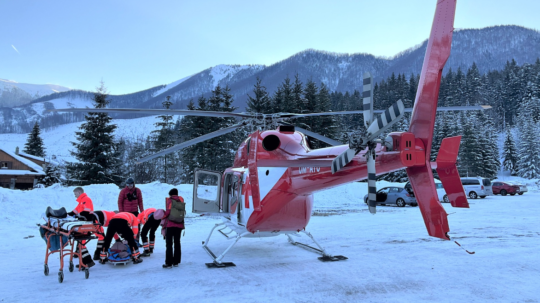 Na snímke horskí záchranári s vrtuľníkom na zasneženom svahu.