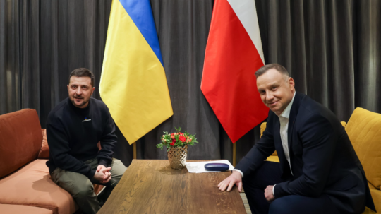 Na snímke ukrajinský prezident Zelenskyj a poľský prezident Duda sedia na sedačkách pred vlajkami svojich krajín.