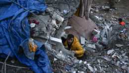 Muž hľadá preživších po silnom zemetrasení v tureckom meste Adana.