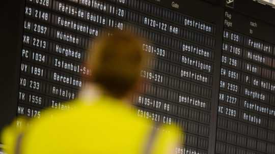 Cestujúci sa pozerá na elektronickú tabuľu so zrušenými letmi na letisku v Hannoveri.