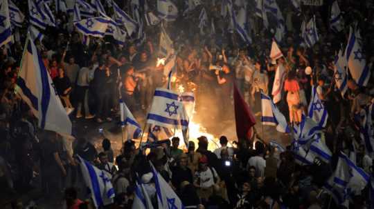 Izraelčania, ktorí nesúhlasia s plánom premiéra Benjamina Netanjahua na revíziu súdnictva, zakladajú ohne a blokujú cestu po odvolaní izraelského ministra obrany Joava Galanta.