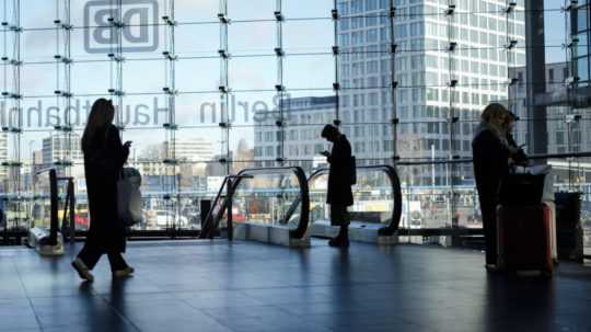 Cestujúci sa pozerajú do svojich mobilov na hlavnej železničnej stanici počas celoštátneho štrajku vo verejnej doprave 27. marca 2023 v Berlíne.