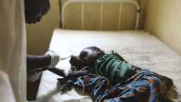 Na archívnej snímke lekár ošetruje dieťa infikované cholerou v dedinskej nemocnici v Nigérii.