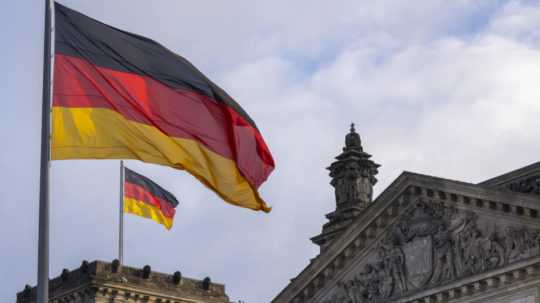 Nemecká vlajke veje na budove parlamentu v Berlíne.