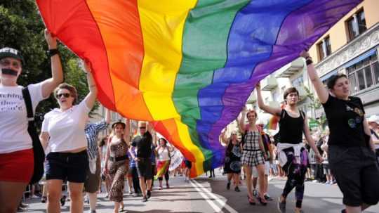 Na snímke účastníci pochodu gayov, lesbičiek, bisexuálov a transsexuálnych osôb držia dúhovú vlajku vo švédskej metropole Štokholm.