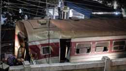Na snímke záchranári odpratávajú následky nehody vlaku v Egypte. Zničený vozeň