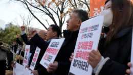 Členovia občianskych skupín protestujú proti plánu juhokórejskej vlády v otázke odškodnenia za nútené práce pred ministerstvom zahraničných vecí v Soule.
