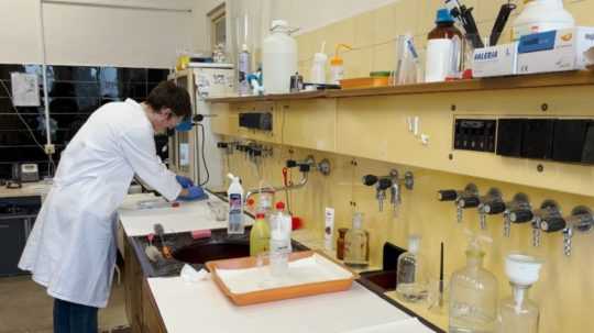 Na snímke študent v bielom plášti v laboratóriu