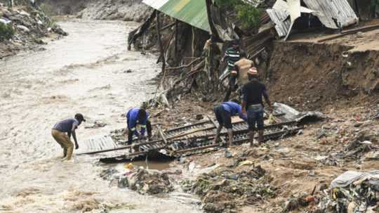 Muži zachraňujú časti zničeného domu po silných dažďoch spôsobených cyklónom Freddy v Blantyre na juhu Malawi v stredu 15. marca 2023.