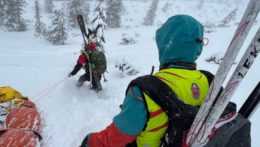 Na snímke záchranári brodiaci sa snehom s lyžami na chrbte
