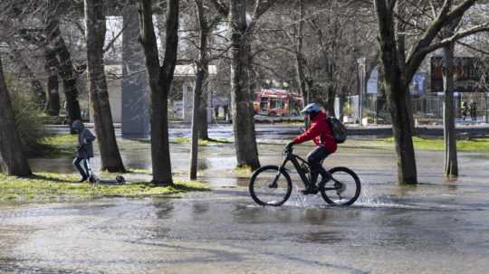 Na snímke cyklista jazdí cez zaplavenú časť Sadu Janka Kráľa.