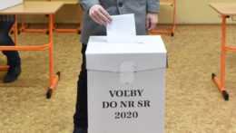 muž vhadzuje lístok do volebnej urny