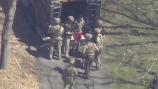 Na videosnímke agenti FBI zadržali 21-ročného Jacka Teixeiru (v červených krátkych nohaviciach).