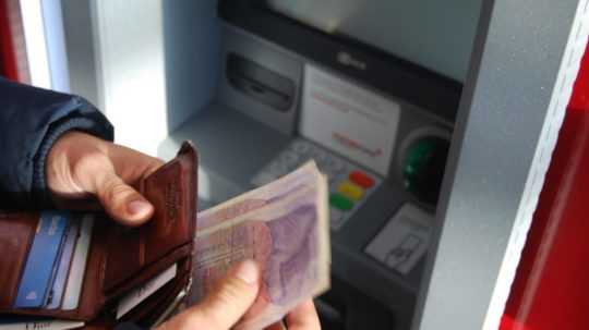 Ilustračná snímka človeka pri bankomate.