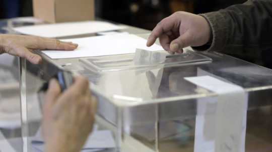 Volič vkladá obálku s hlasovacími lístkami do volebnej schránky počas predčasných parlamentných volieb v bulharskej Sofii.