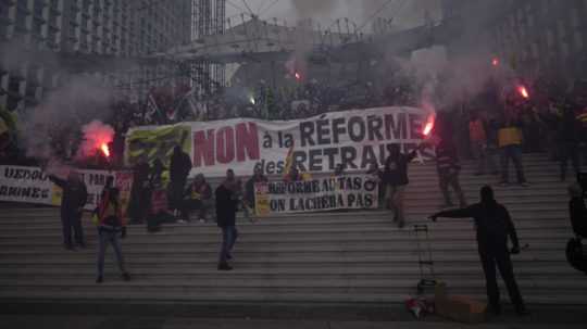 Demonštranti držia dymovnice a transparenty počas demonštrácie proti reforme dôchodkového systému.