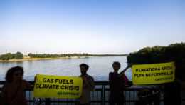 Na archívnej snímke aktivisti stoja pri Dunaji s bannermi s nápisom: Klimatická kríza plyn nepotrebuje