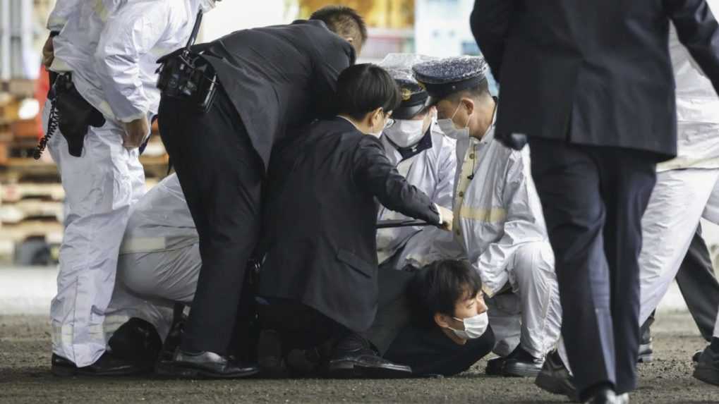 Policajti zatýkajú muža, ktorý je považovaný za podozrivého (uprostred na zemi) po tom, čo údajne hodil podozrivý predmet počas prejavu japonského premiéra Fumia Kišidu.