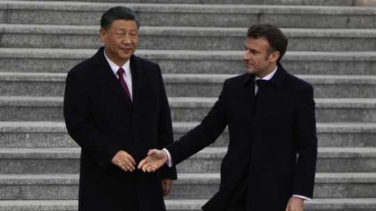 Francúzsky prezident Emmanuel Macron (vpravo) si podáva ruku s čínskym prezidentom Si Ťin-pchingom pred ich stretnutím v Pekingu.