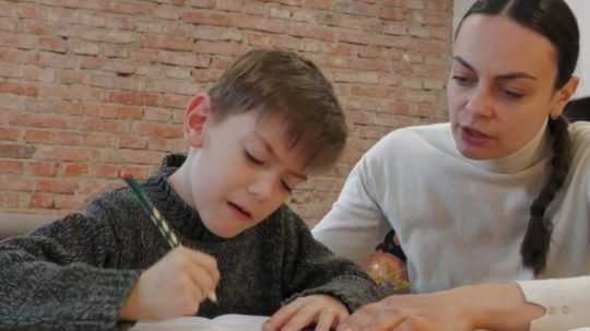 Na snímke mama pomáha svojmu synovi s domácimi úlohami