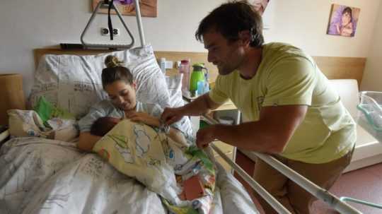 žena a muž s dieťaťom na pôrodníckom oddelení