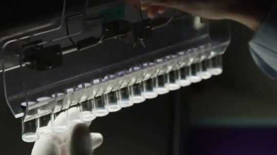 Pracovník laboratória na snímke pracuje s ampulkami určenými na vakcíny.
