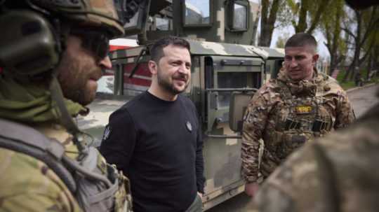 Na snímke ukrajinský prezident Volodymyr Zelenskyj (uprostred) sa rozpráva s vojakmi.