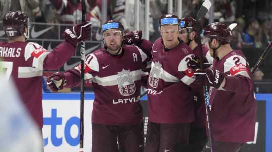 Lotyšskí hokejisti oslavujú gól proti Slovinsku
