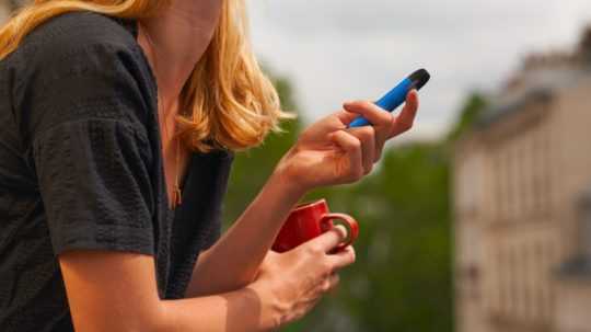 Na snímke žena drží elektronickú cigaretu,