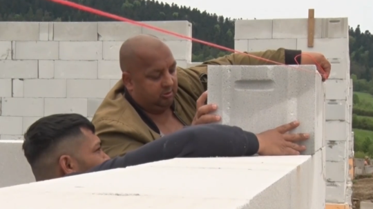 Na snímke muži pracujúci na stavbe.
