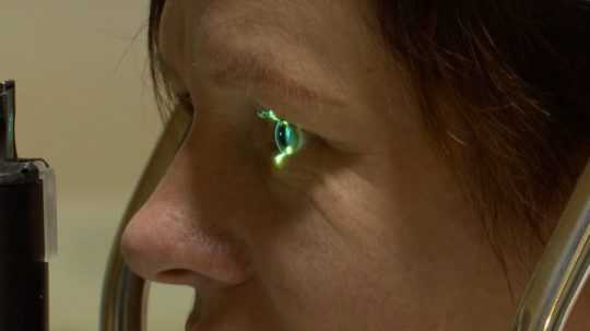 Žena sa pozerá do očného diagnostického prístroja.