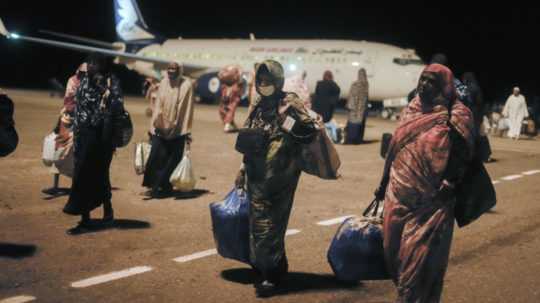 Sudánci, ktorí uviazli v Džidde, v Saudskej Arábii, prichádzajú s taškami na letisko v meste Port Sudan