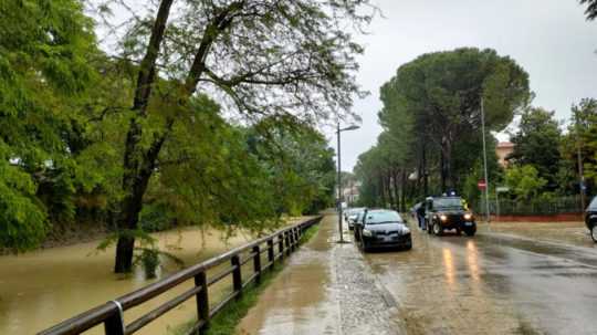Na snímke zaplavená ulica a na nej auto.