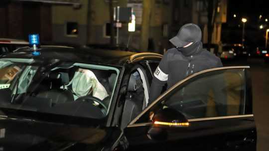 Na ilustračnej snímke policajt nasadá do policajného auta.