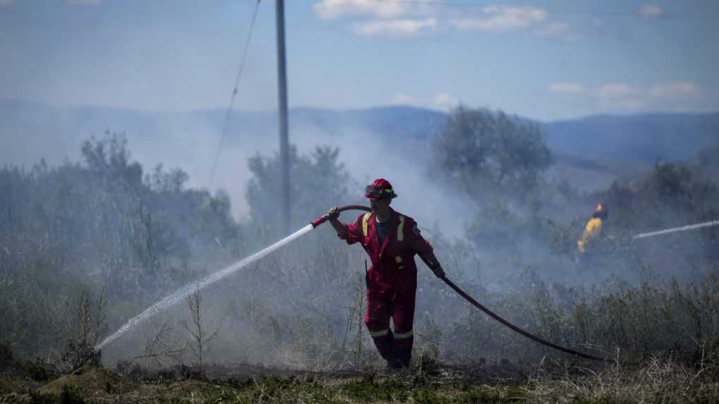 Požiarnik hasí požiar v tráve v Kamloopse v Kanade.
