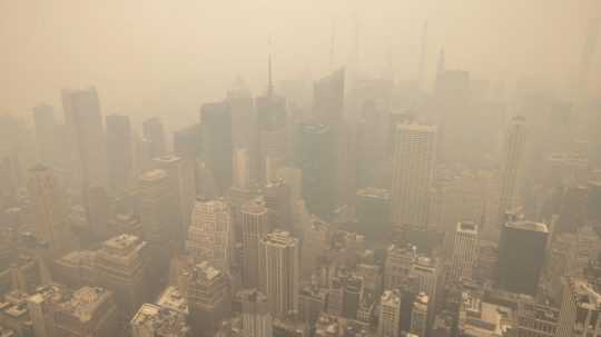 Panoráma New Yorku je zahalená dymom pri pohľade z budovy Empire State Building.