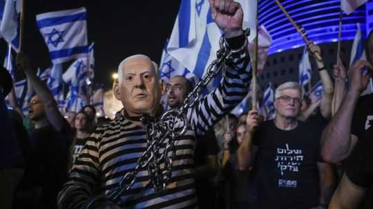 Protestujúci s maskou tváre izraelského premiéra Benjamina Netanjahua v Izraeli.