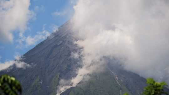 Z krátera sopky Mayon vystupujú husté sopečné mračná z popola a úlomkov hornín.