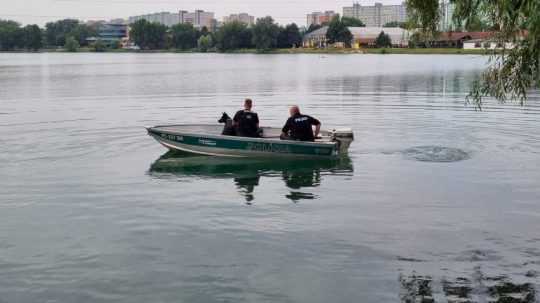 Policajti v člne pátrajú po utopenom mužovi.