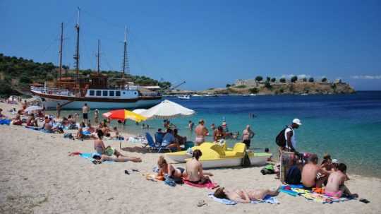 Na snímke sú turisti na gréckej pláži.