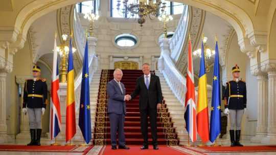 Britský kráľ Karol III. (vľavo) si podáva ruku s rumunským prezidentom Klausom Iohannisom.