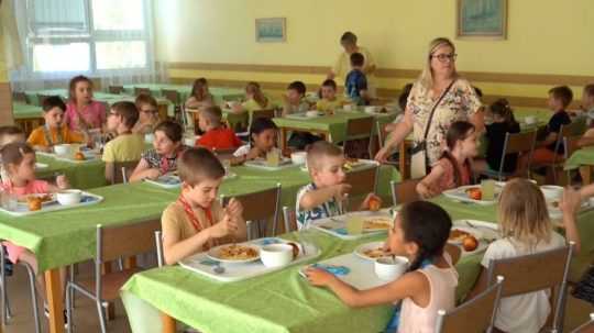 Na snímke školská jedáleň plná obedujúcich detí.