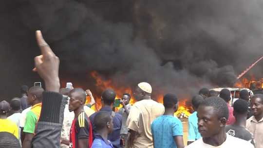 Hustý čierny dym stúpa zo sídla vládnucej strany počas demonštrácie v nigerskom hlavnom meste Niamey.